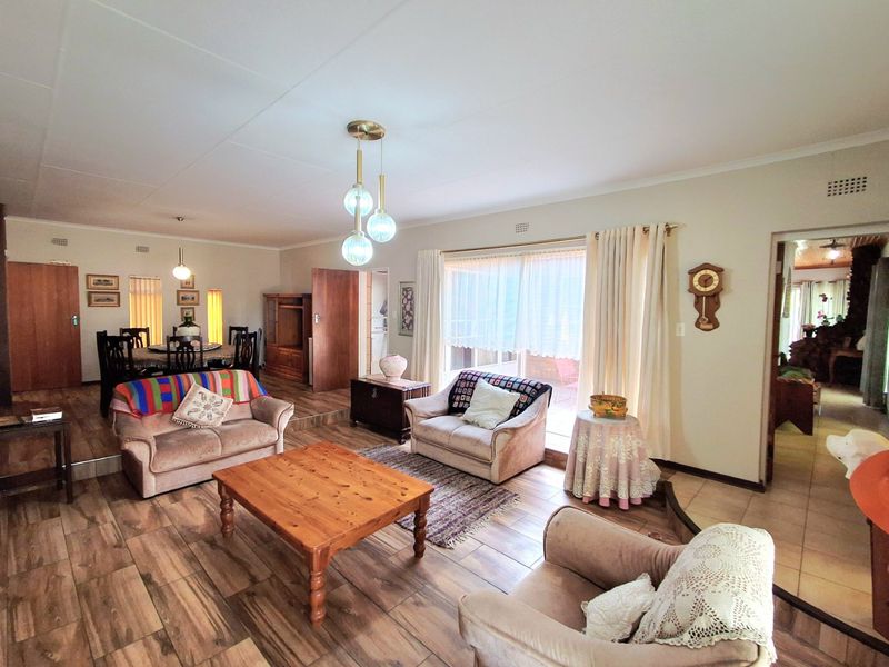 Spacious open-plan living and dining area featuring tiled flooring, neutral walls, and large sliding glass doors providing access to the outdoor space.