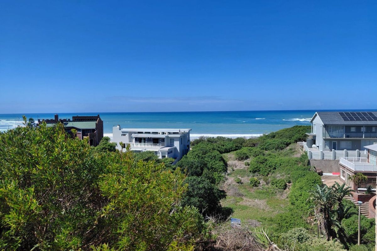 A scenic elevated view overlooking the coastal landscape, surrounding residential properties, and the ocean horizon.