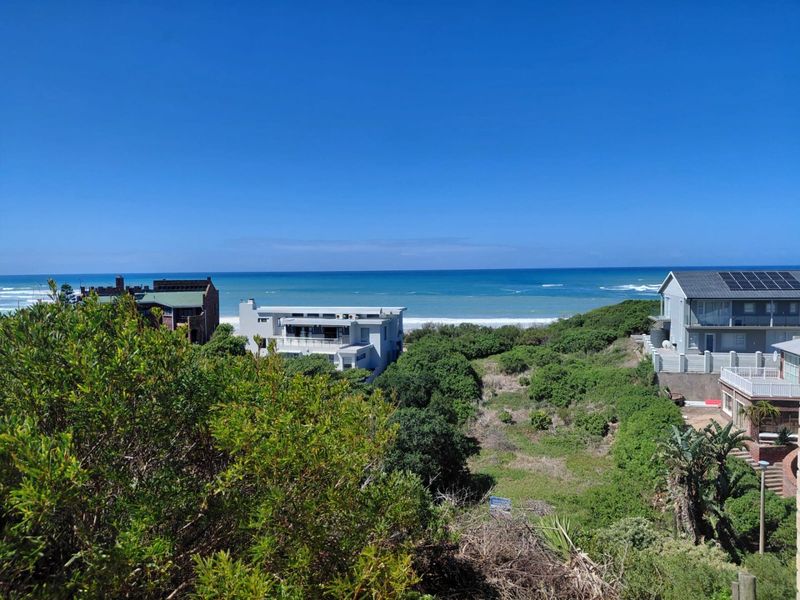 A scenic elevated view overlooking the coastal landscape, surrounding residential properties, and the ocean horizon.