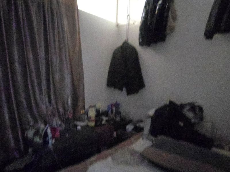 A dimly lit bedroom space with heavy curtains and limited visibility of architectural features.