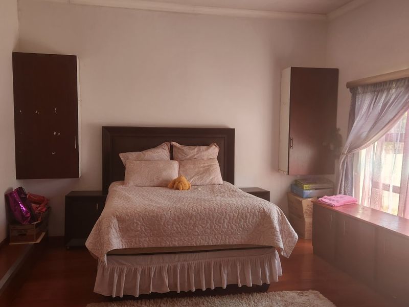 A bedroom featuring laminate flooring, recessed lighting, and built-in cabinetry flanking the bed area.