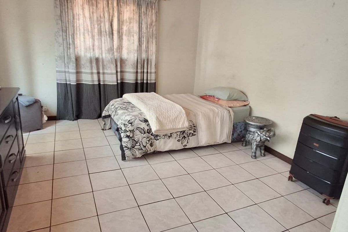 A bedroom featuring tiled flooring and neutral wall finishes, offering a functional space ready for cosmetic updates and personalization.