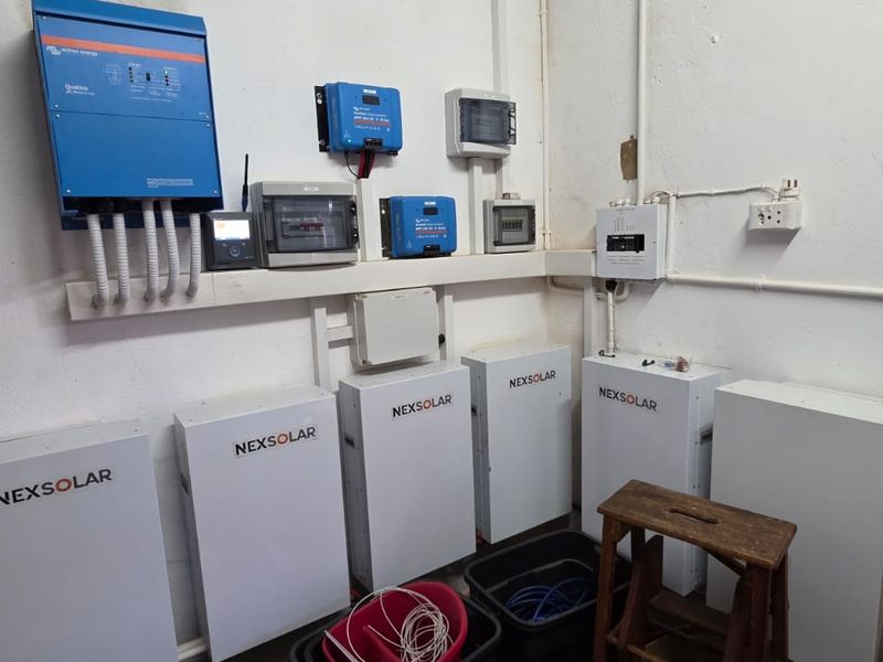 Utility space featuring a comprehensive solar power installation with multiple Nexsolar battery storage units and Victron Energy inverters.