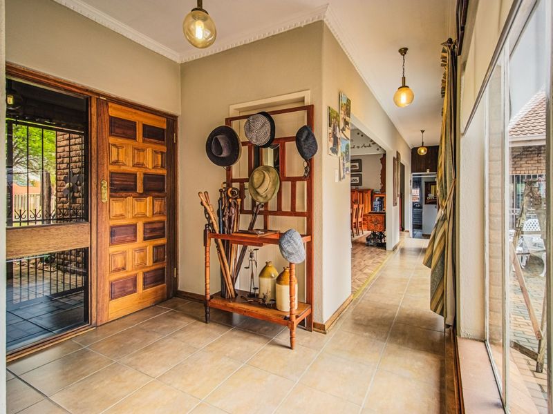 Welcoming entrance hall featuring tiled flooring, a solid wood panel door, and large glass sliding doors that provide natural light and access to the exterior.