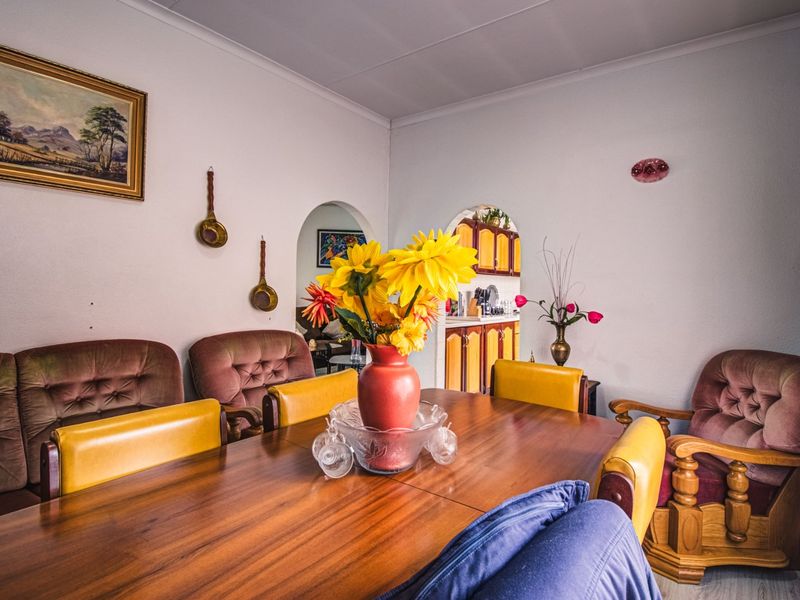A traditional dining room featuring an arched doorway leading to the kitchen area and classic coved ceiling detailing.