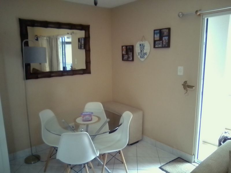 A compact dining area featuring tiled flooring and direct access to an outdoor space through a sliding glass door.