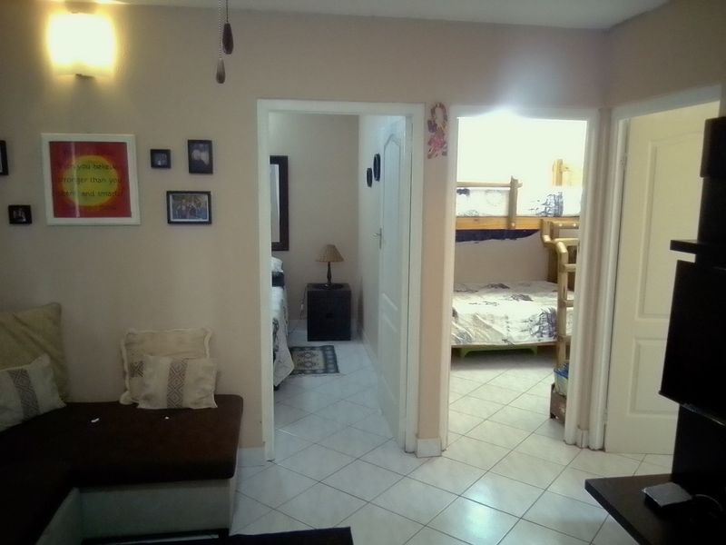 A hallway area featuring tiled flooring and access to multiple bedrooms, providing a central circulation space within the apartment.