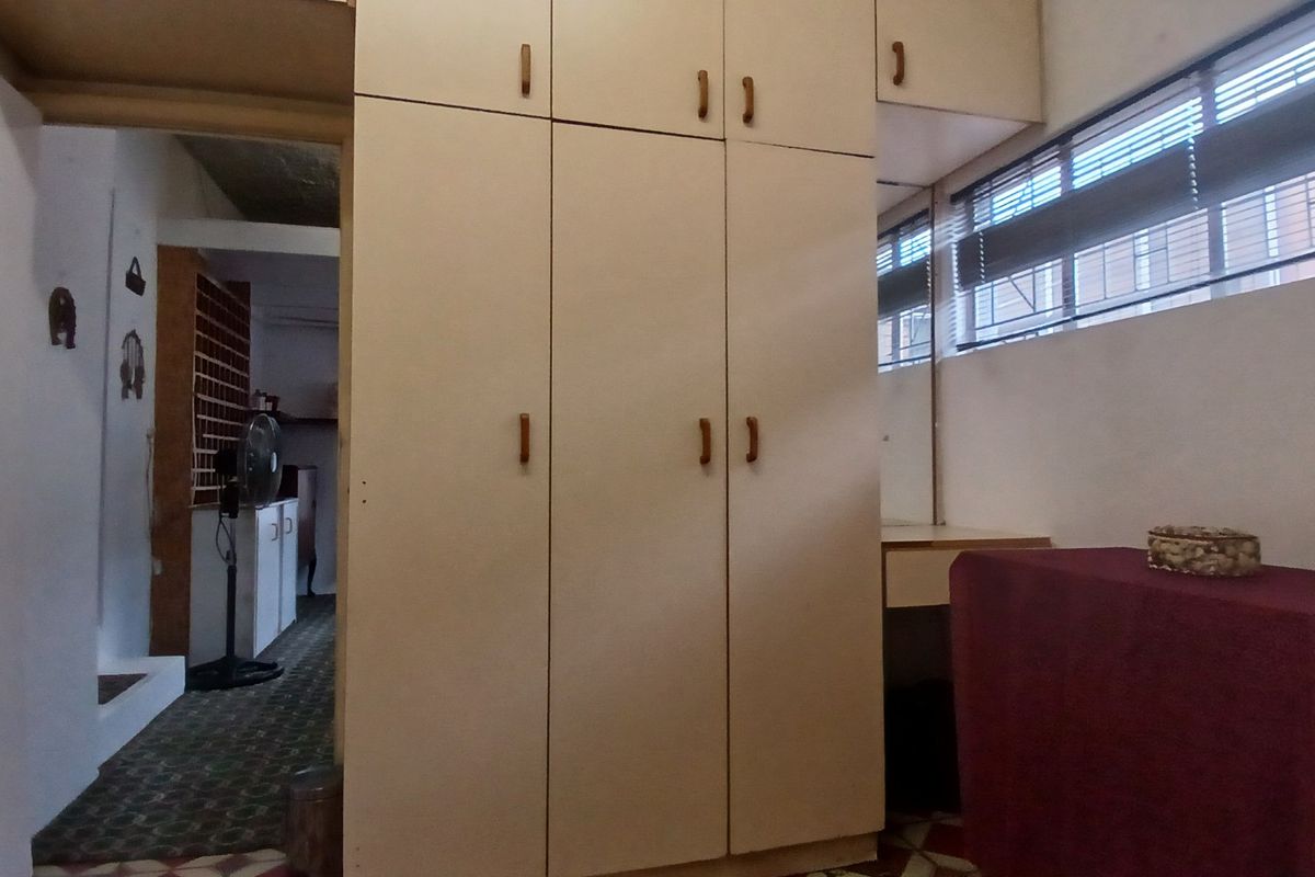 Bedroom featuring extensive built-in cabinetry with integrated vanity and horizontal window blinds.