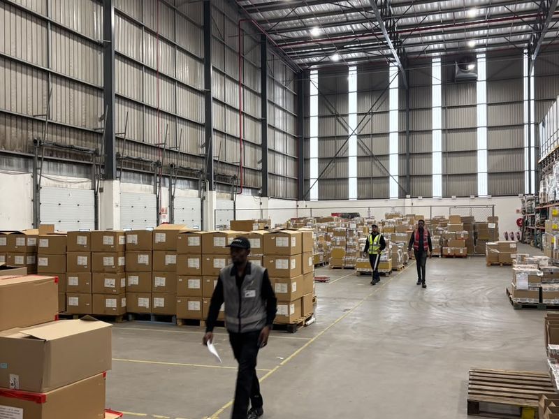 Spacious industrial warehouse featuring high-bay lighting, exposed steel roof trusses, concrete flooring, and multiple loading dock doors for efficient logistics operations.