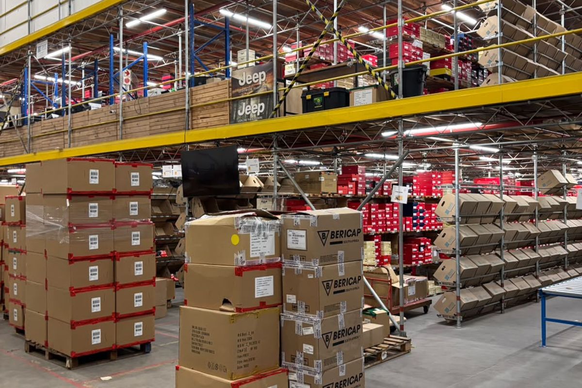 Spacious industrial warehouse featuring high-level steel racking, mezzanine storage, durable concrete flooring, and efficient overhead fluorescent lighting.
