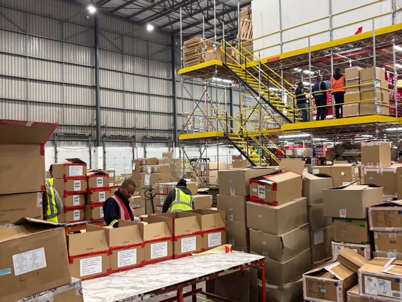 Spacious industrial warehouse facility featuring high-clearance ceilings, exposed steel trusses, a mezzanine storage level with staircase access, and durable concrete flooring.