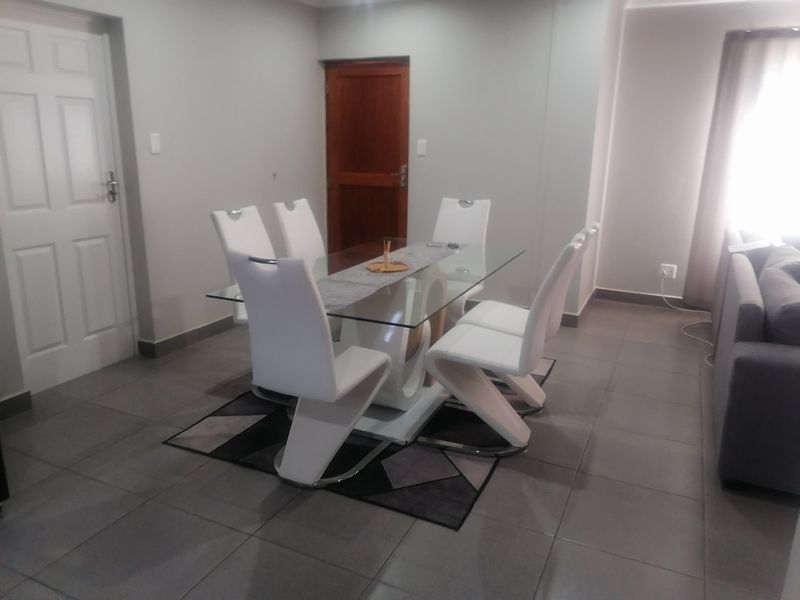 A dining area featuring neutral wall tones, tiled flooring, and a functional layout suitable for family meals.