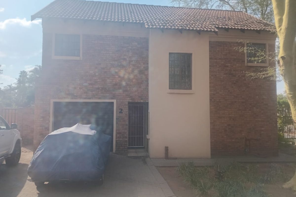 Front elevation of a two-story brick house featuring a paved driveway, garage, and security entrance.