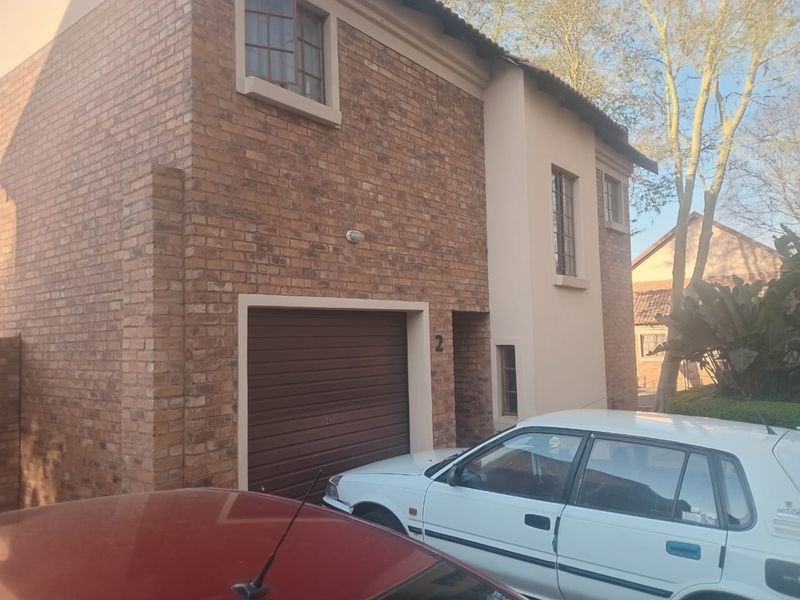 Front elevation of a double-storey face-brick house featuring a single garage and classic casement windows.
