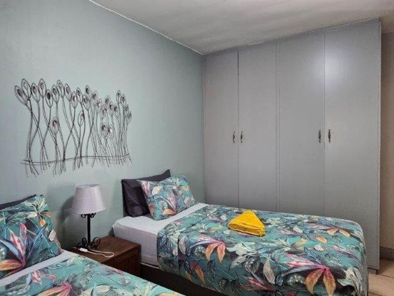 A bedroom featuring built-in cupboards and tiled flooring, providing functional storage and a neutral base for interior design.