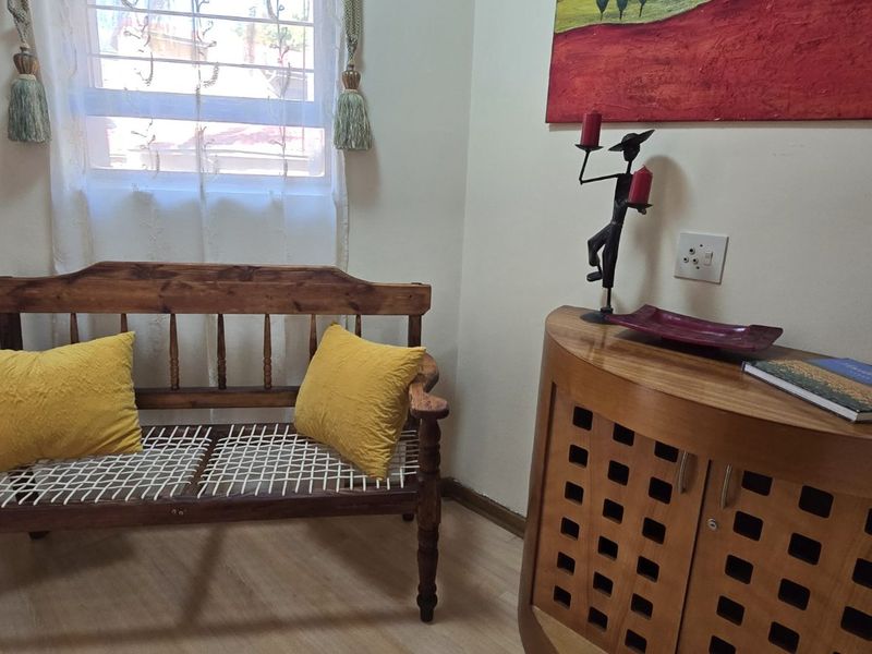 A compact entry area featuring laminate flooring, an intercom system, and a window with natural light.