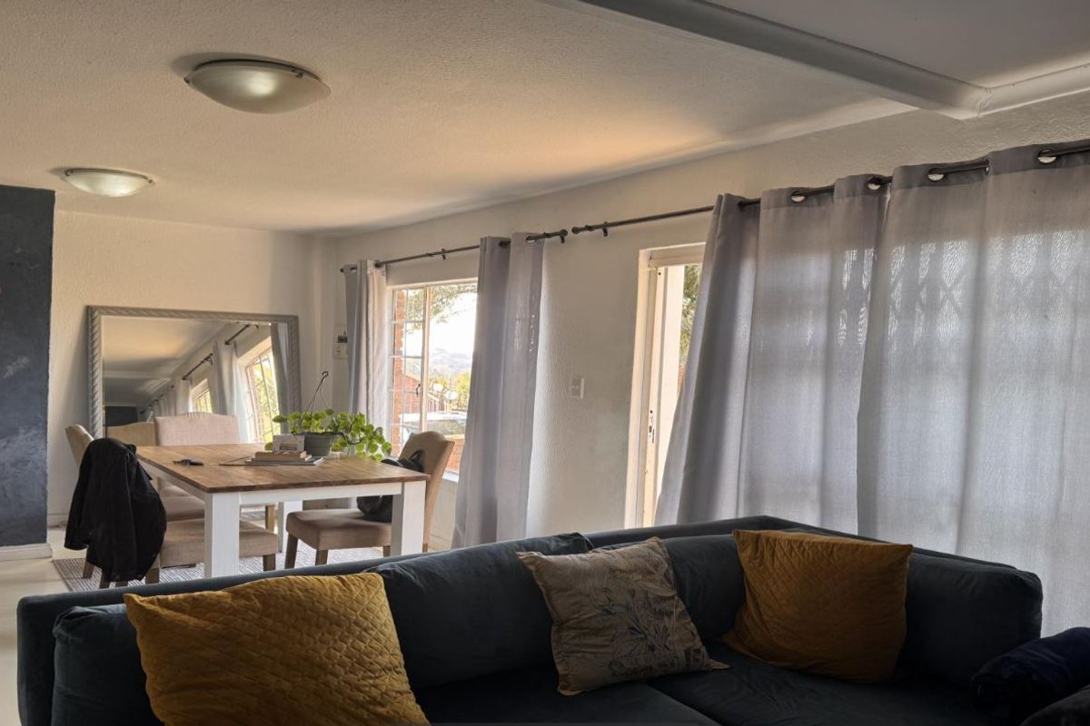 Open plan living and dining area featuring neutral finishes, floating wall shelves, and sliding glass doors providing access to the exterior.