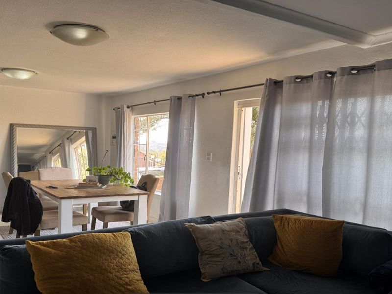 Open plan living and dining area featuring neutral finishes, floating wall shelves, and sliding glass doors providing access to the exterior.