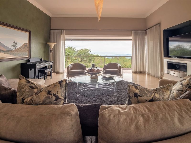 Spacious living room featuring a built-in fireplace, recessed television niche, and large sliding doors opening to a scenic outdoor balcony.
