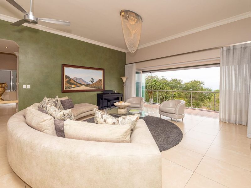 Spacious living room featuring large stacking glass doors that open onto a balcony, tiled flooring, and a modern ceiling fan.