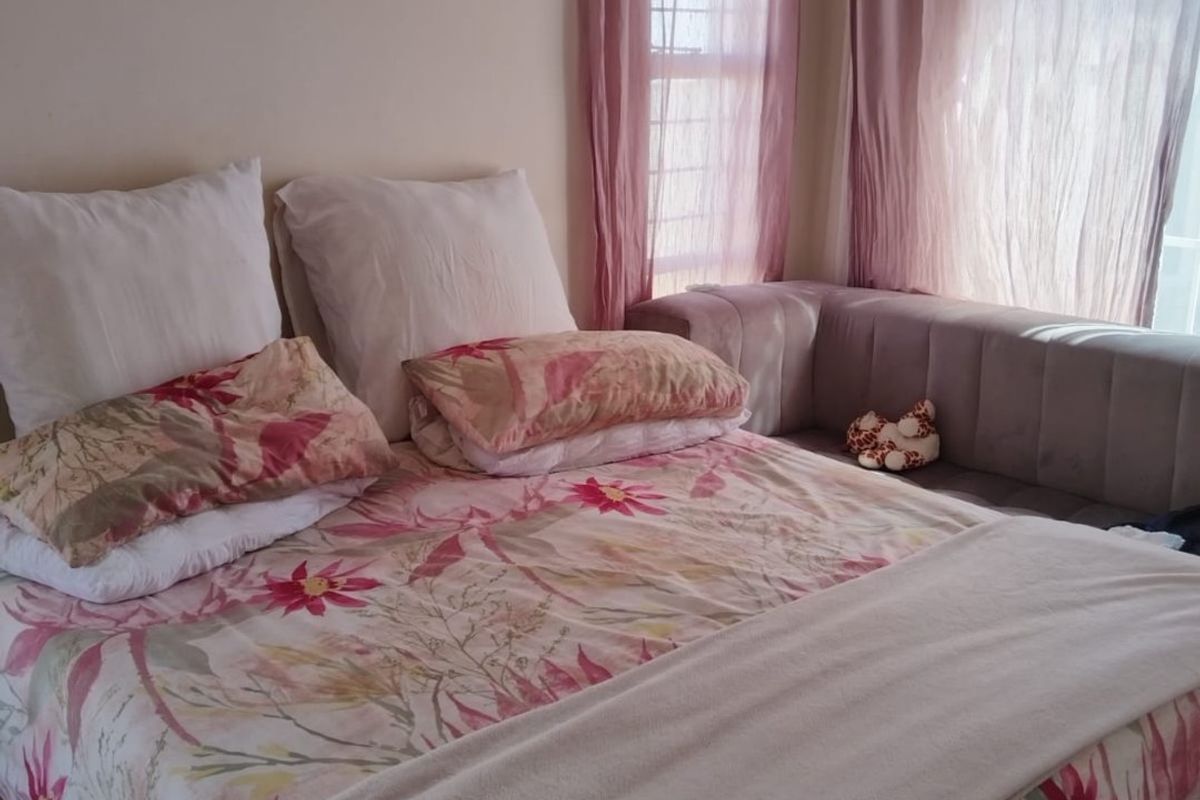 A bedroom featuring neutral walls and natural light through windows with installed curtain rails.