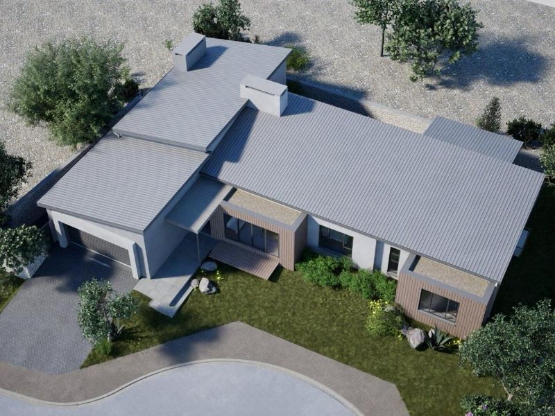 Aerial view of a modern single-story house featuring a corrugated metal roof, timber cladding accents, a paved driveway, and a landscaped garden.