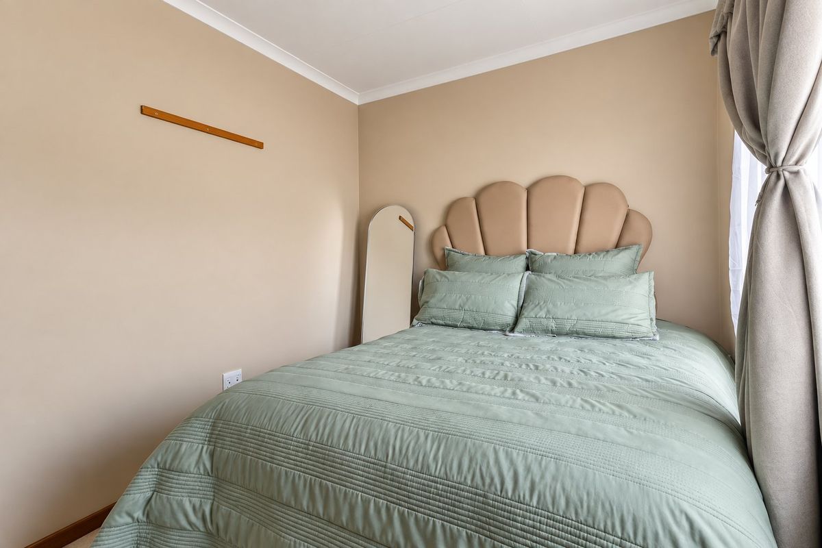 A neutrally painted bedroom featuring coving and a standard electrical outlet, providing a clean and functional space.