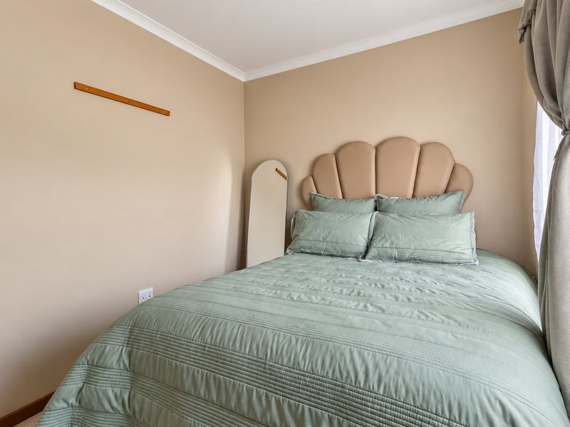 A neutrally painted bedroom featuring coving and a standard electrical outlet, providing a clean and functional space.