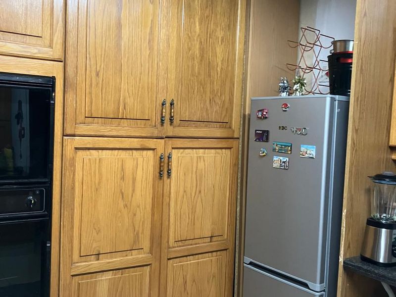 A kitchen area featuring traditional wooden cabinetry and a built-in oven, providing functional storage and cooking space.