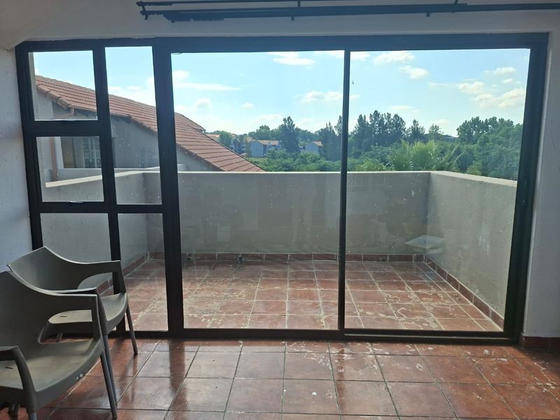 A private balcony featuring tiled flooring, a parapet wall, and large sliding glass doors providing access to the outdoor space.