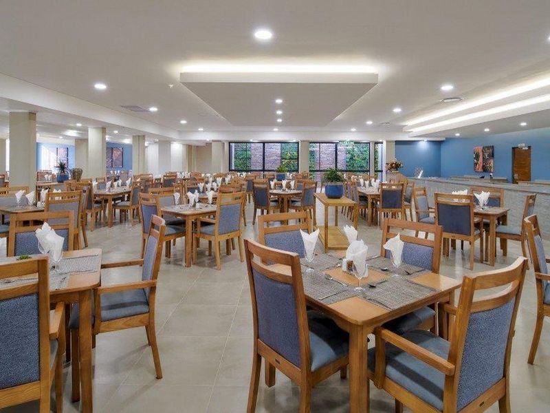 Spacious dining area featuring modern recessed ceiling lighting, a dropped ceiling architectural detail, and neutral tiled flooring throughout.