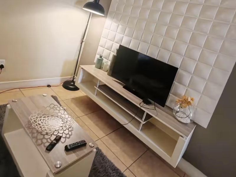 A living room area featuring a decorative textured wall panel and tiled flooring.