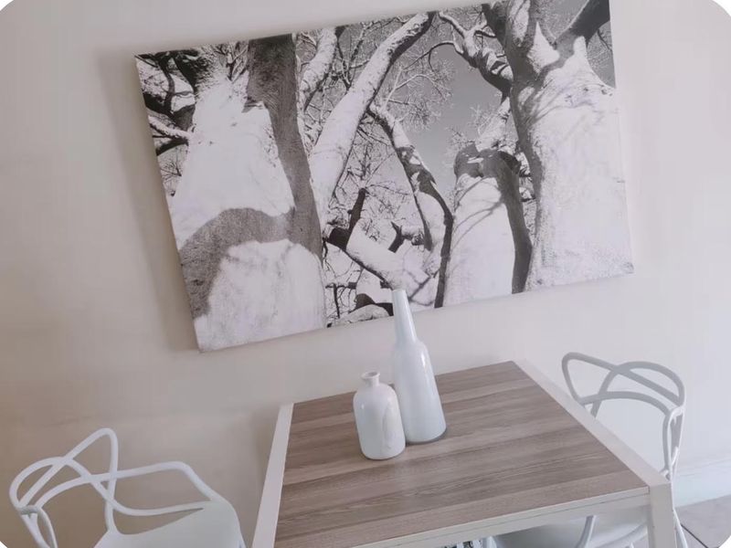 A close-up view of a small dining table and wall art, providing insufficient architectural information to determine the room type.