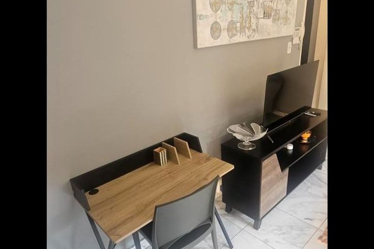 A living area featuring neutral wall tones and light-colored tiled flooring, providing a clean and functional space.
