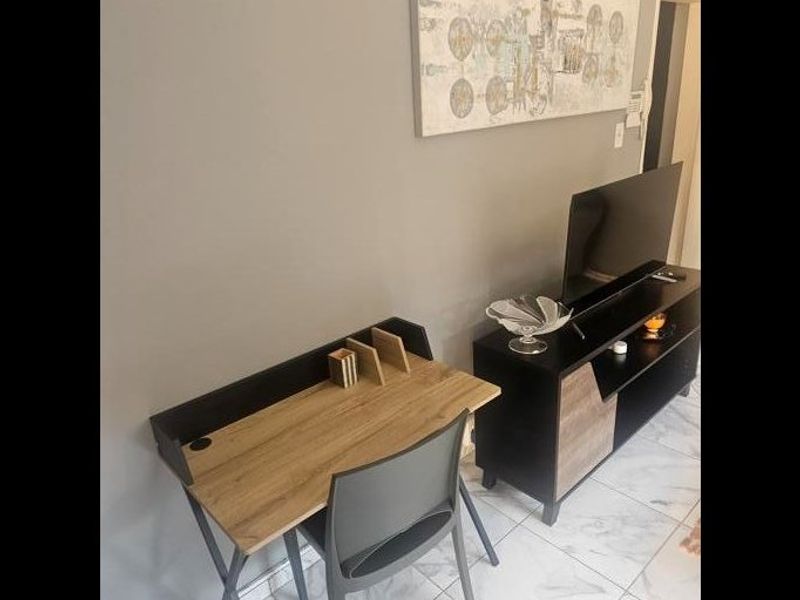 A living area featuring neutral wall tones and light-colored tiled flooring, providing a clean and functional space.