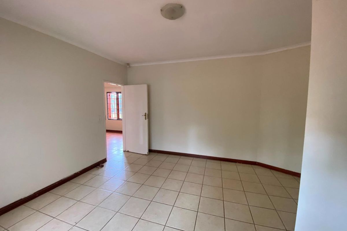 A bright, empty living area featuring neutral tiled flooring and clean walls, providing a versatile blank canvas for interior design.