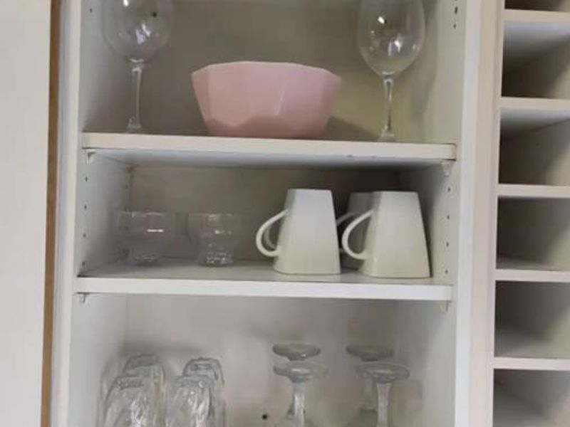 A close-up view of open kitchen cabinetry featuring adjustable shelving and a dedicated wine storage rack.