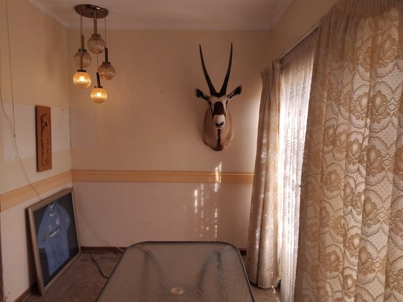 Dining area featuring a pendant light fixture, chair rail molding, and sliding glass door access to the exterior.