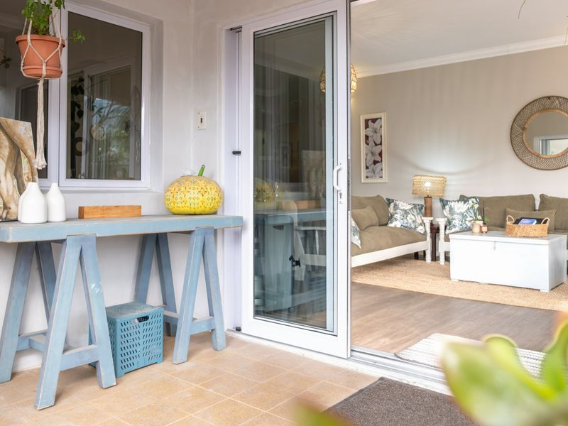 A covered patio area featuring tiled flooring and a large sliding glass door providing seamless access to the interior living space.