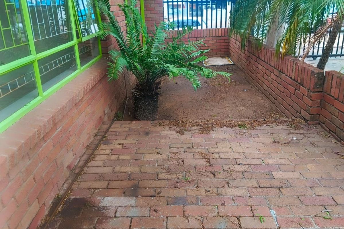 A private rear courtyard area featuring brick paving, enclosed by brick boundary walls and security fencing, offering a low-maintenance outdoor space.