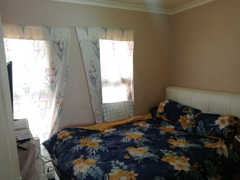 A bedroom featuring neutral wall tones and cove cornicing, requiring cosmetic updates to improve the overall finish and aesthetic appeal.