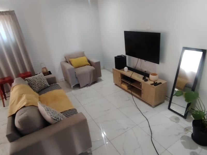 A bright living room featuring modern white marble-look porcelain floor tiles and neutral wall finishes, providing a clean and contemporary foundation.