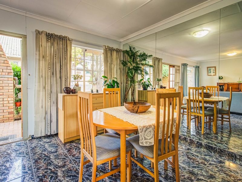 Dining area featuring tiled flooring, a large mirrored wall, and direct access to an outdoor patio space.