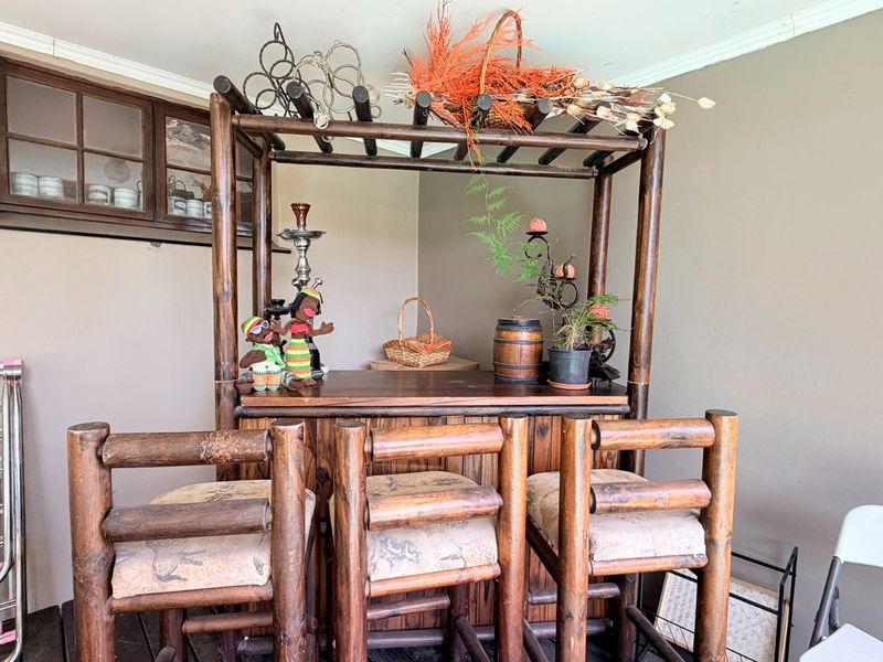 A covered patio area featuring a timber-framed window and neutral wall finishes, providing a functional outdoor entertainment space.