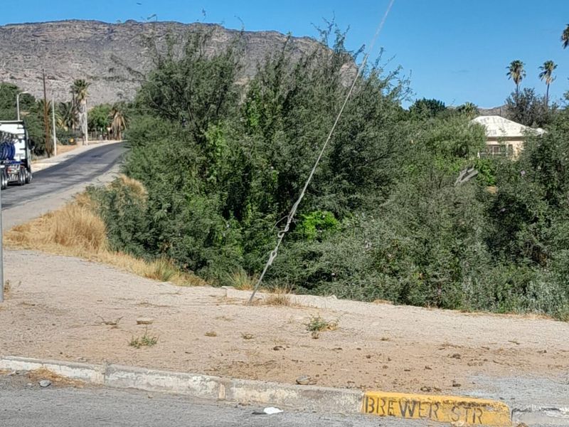A street-level view of the property frontage showing the road, kerb, and surrounding landscape.