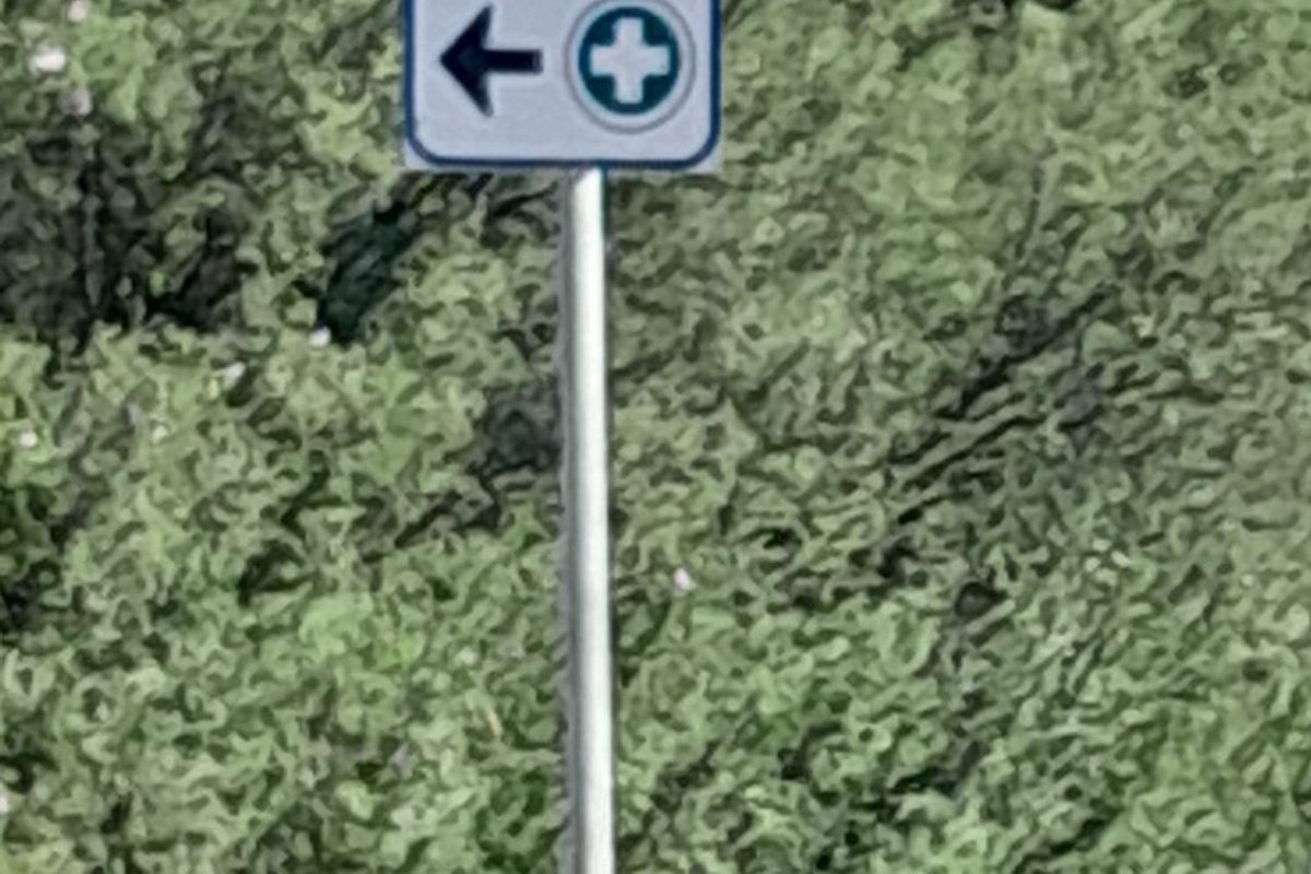 A directional sign indicating a medical or first aid point located on the property.