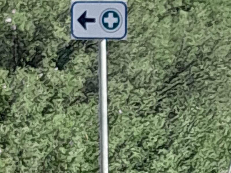A directional sign indicating a medical or first aid point located on the property.