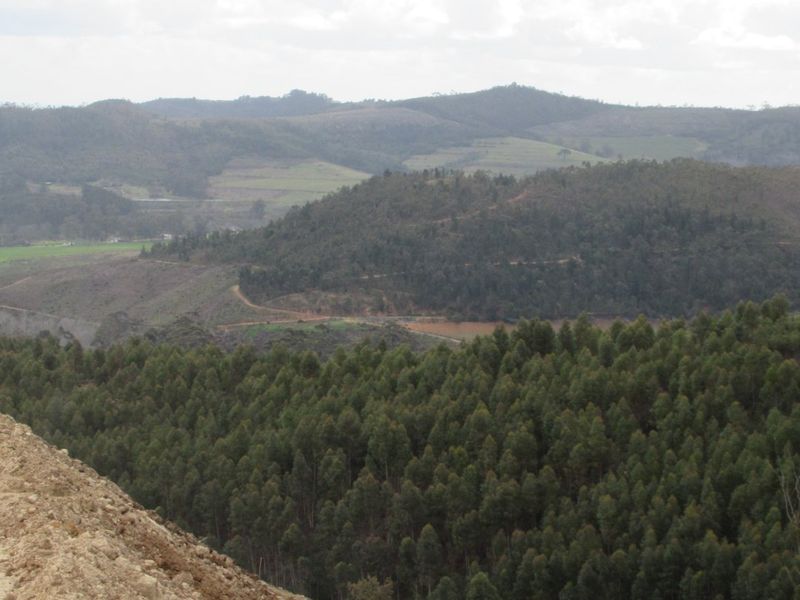 A scenic view overlooking a vast landscape featuring rolling hills and dense forest vegetation.