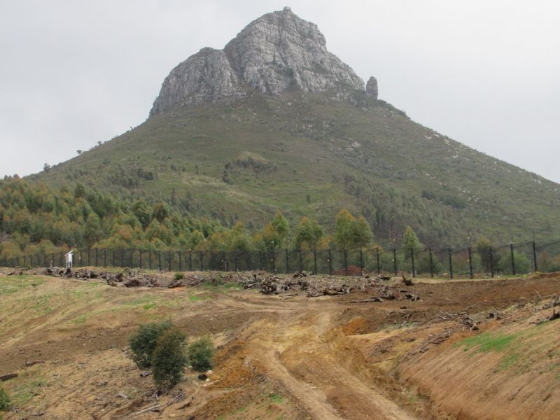 A view of the vacant residential land featuring a prominent mountain backdrop and perimeter fencing.
