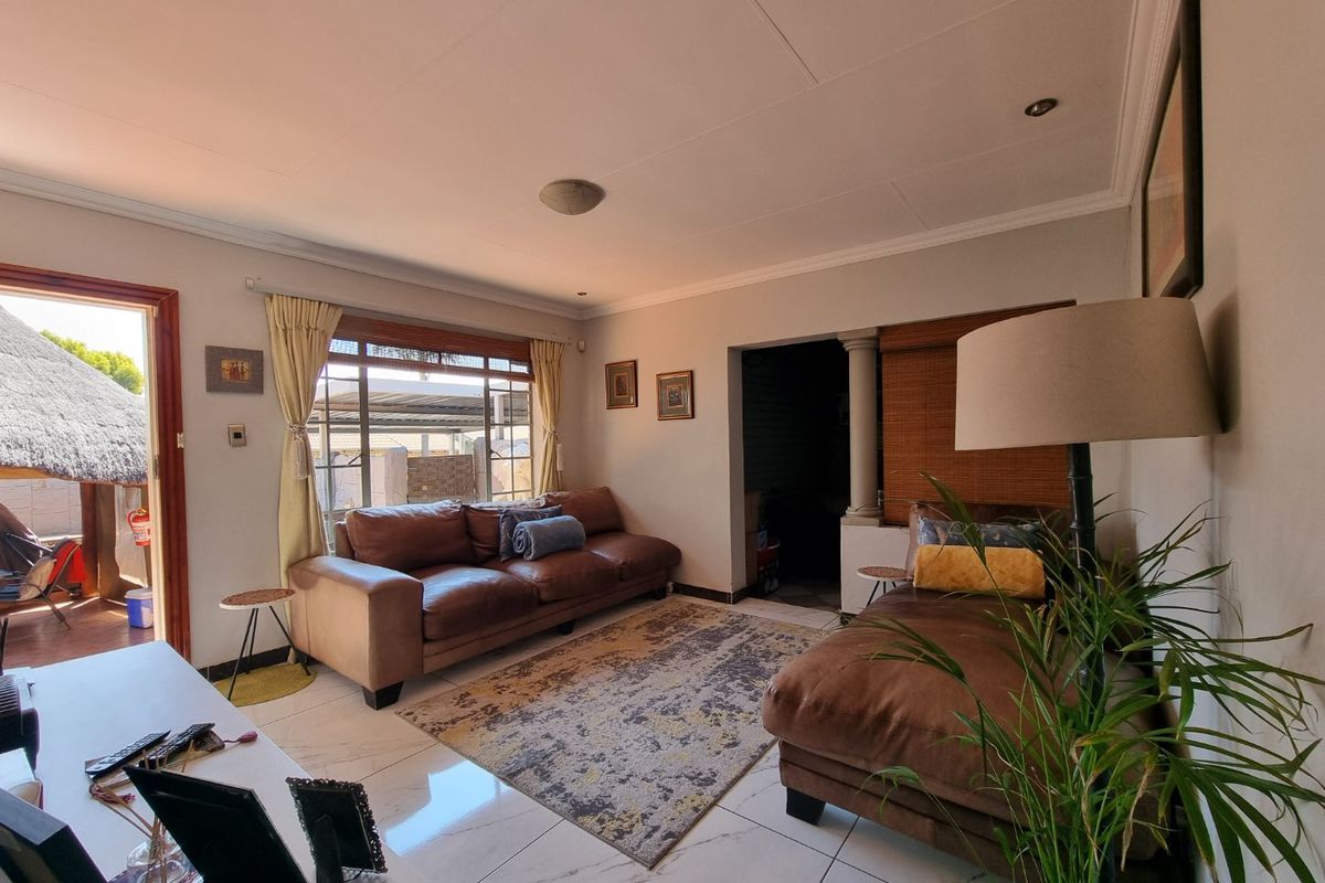 A comfortable living room featuring tiled flooring, recessed lighting, and direct access to an outdoor patio area.